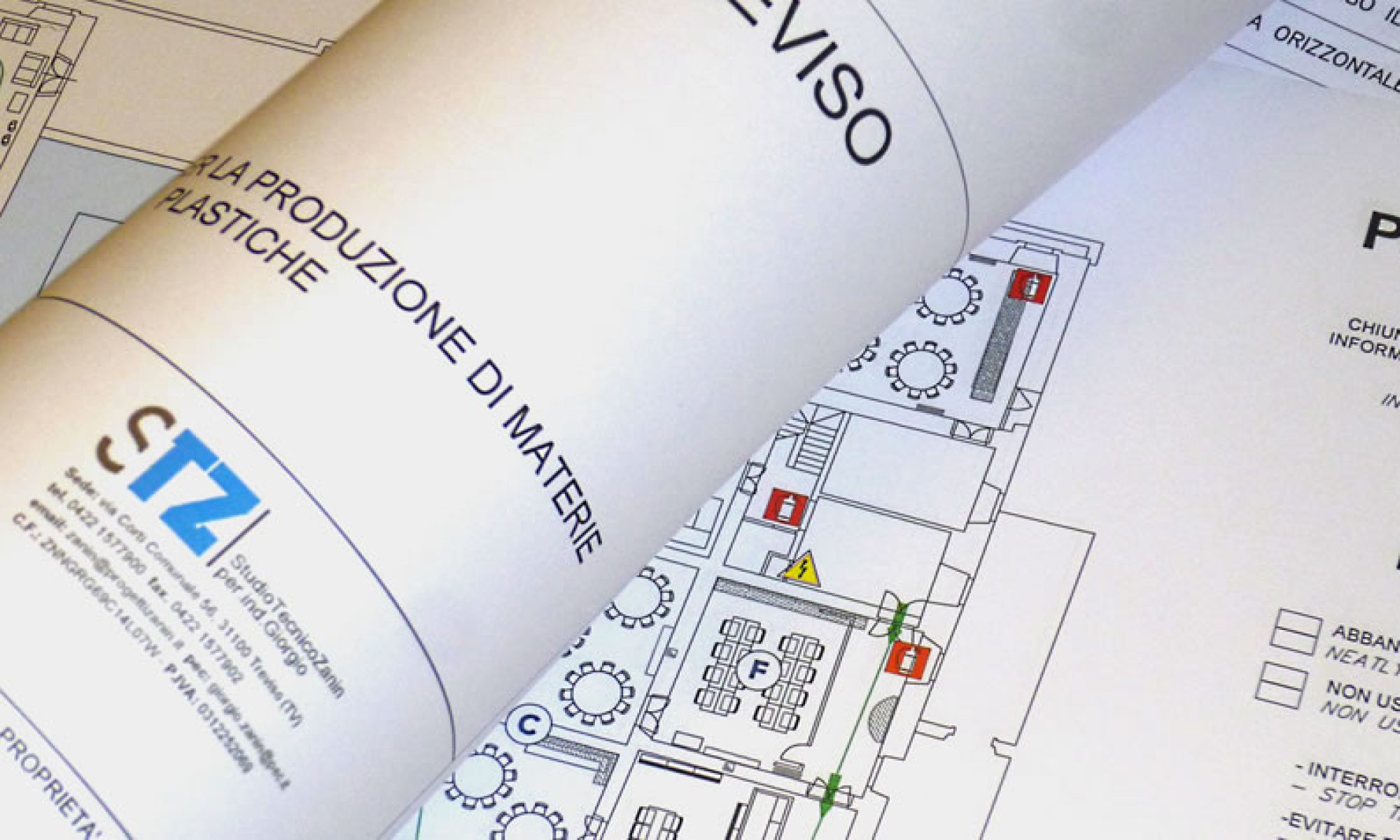 Un progetto arrotolato appoggiato sopra una planimetria