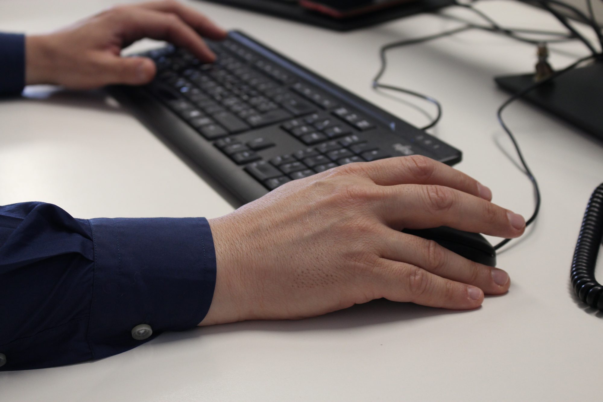 Una mano maschile che lavora sulla tastiera di un computer